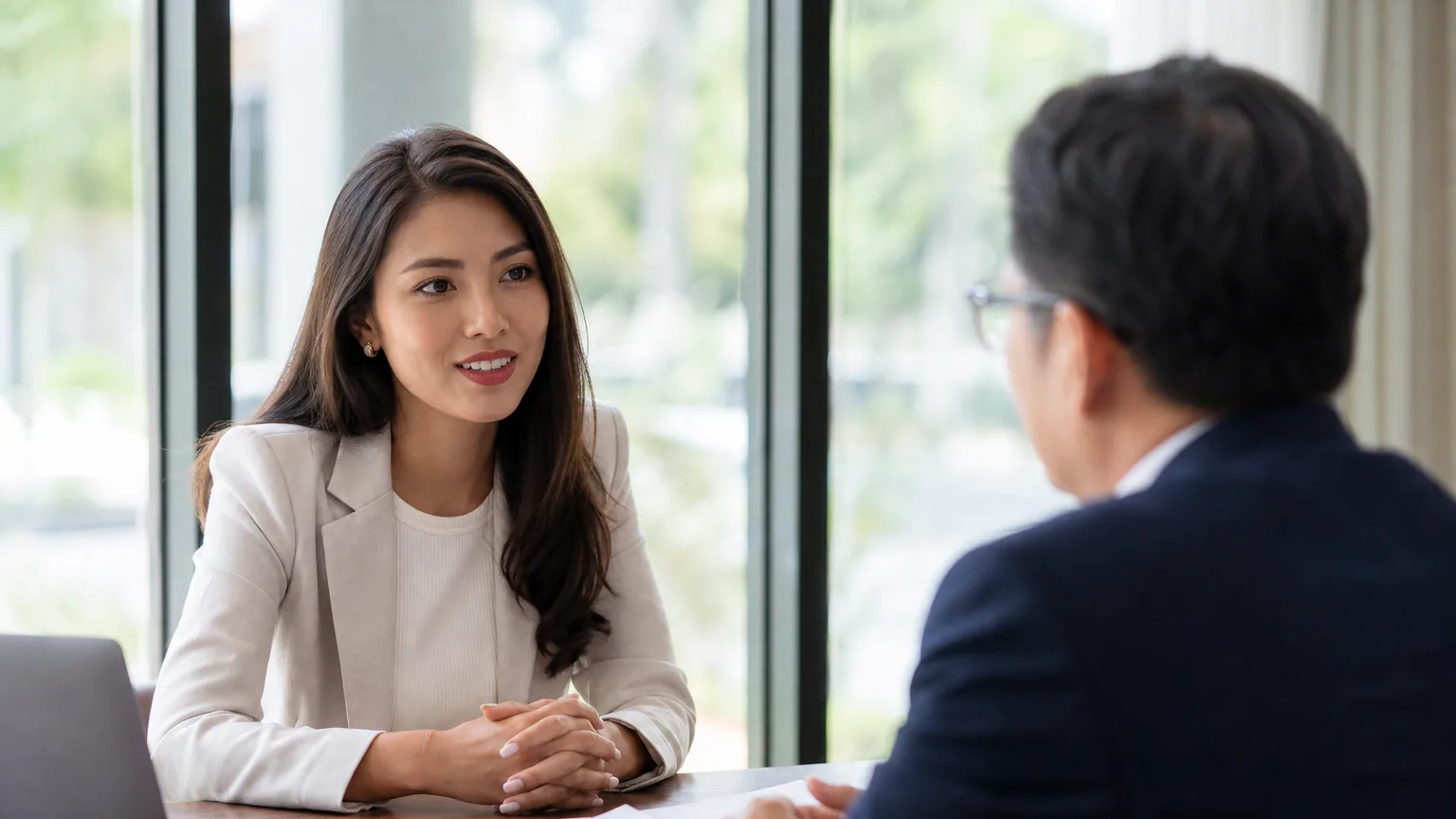 Une candidate discute calmement de sa rémunération face à un recruteur lors d'un entretien